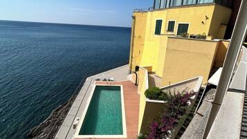 A residential building with a pool and a view of the sea.