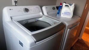 A front-loading LG washing machine with a control panel, detergent bottles, and a water inlet. - Spacious 5-bedroom building in serene Avon with AC (Avon)