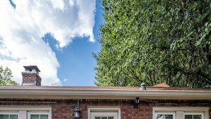 A single-story brick house with a front door, two windows, a chimney, and a small porch. - Walk to Broad Ripple & Monon Trail | Fire Pit | Family Home | Sleeps 8 (Indianapolis)