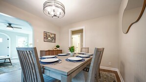 A dining room with a rectangular table, six chairs, and a chandelier. - Walk to Broad Ripple & Monon Trail | Fire Pit | Family Home | Sleeps 8 (Indianapolis)