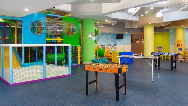 A children's play area with a climbing structure, a foosball table, and a slide. - Luxury 1BR Suite at Villa del Palmar Flamingos – Beachfront Resort (Nay.)