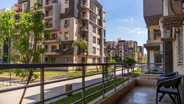 A residential building with multiple balconies, a paved walkway, and greenery. - CK 803 . Spacious 2BR Apt., 2 Baths (Sheikh Zayed City)