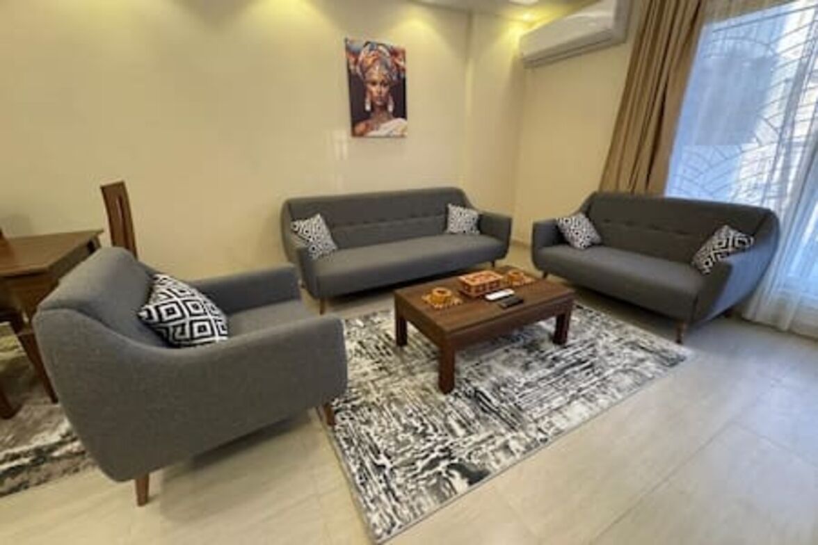 A living room with two grey sofas, a coffee table, and a patterned rug.