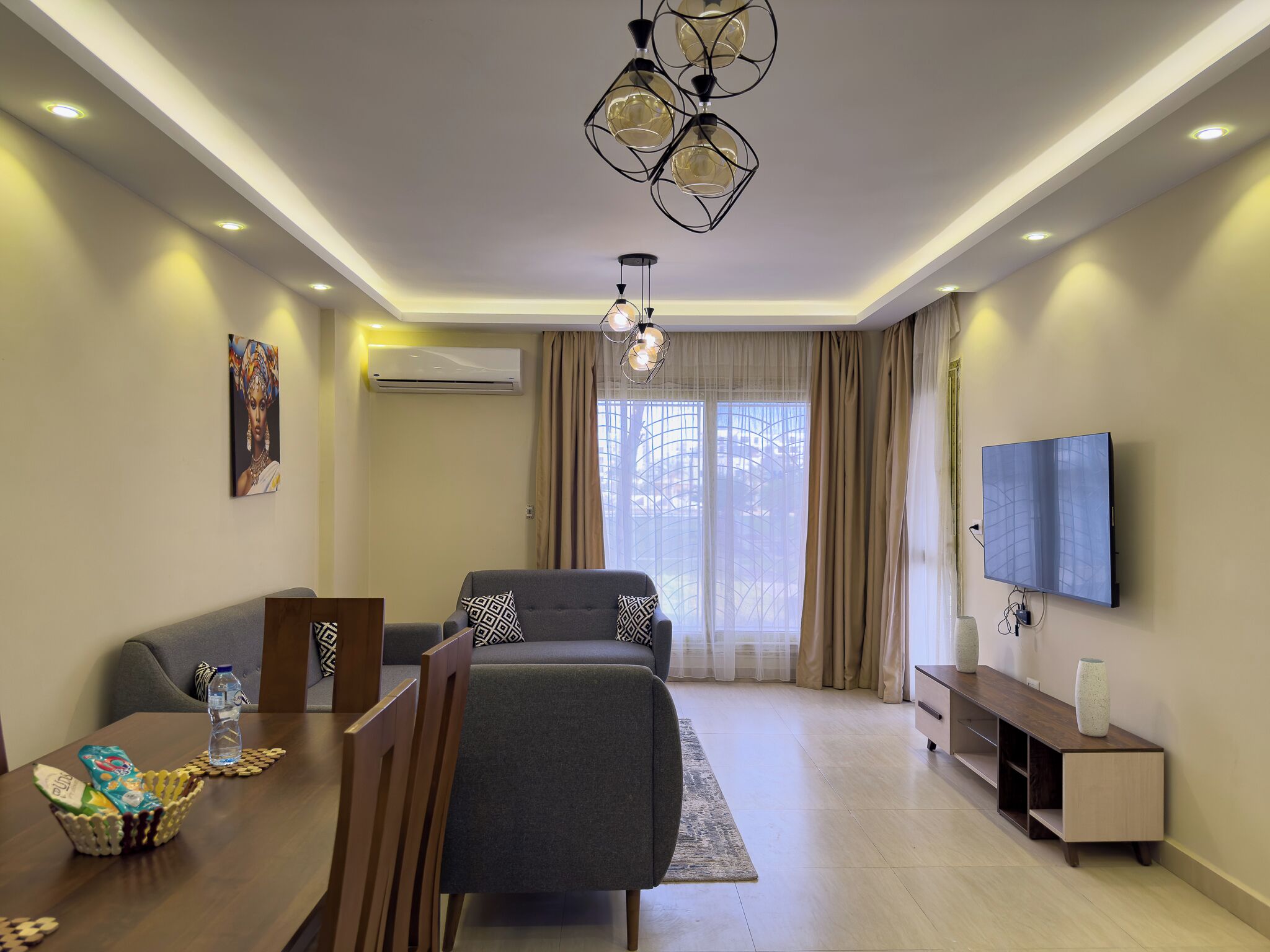 A modern living room with a sofa, dining table, and a TV.