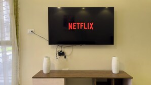 A flat-screen TV mounted on a wall with a Netflix logo displayed. - CK 803 . Spacious 2BR Apt., 2 Baths (Sheikh Zayed City)