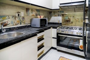 A kitchen with a microwave, stove, and oven. - CK 803 . Spacious 2BR Apt., 2 Baths (Sheikh Zayed City)