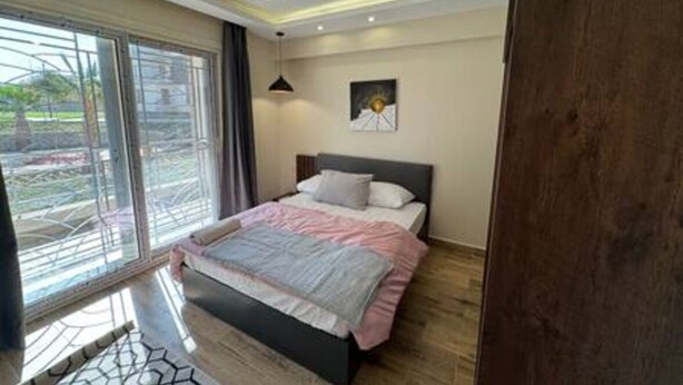 A bedroom with a bed, a window, and a ceiling light fixture. - CK 903 . Spacious 2BR Apt., 2 Baths (Sheikh Zayed City)
