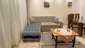 Una habitación con sofá, una mesa de comedor y un tapete estampado.