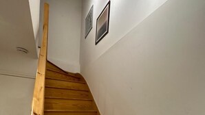 Un escalier en bois, doté d’une rampe, mène à un palier.