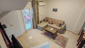A living room with a sofa, a coffee table, and a patterned rug.
