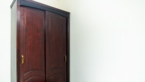Un armario de madera grande con dos puertas y un pomo en cada una.