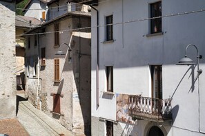 Eine enge Straße mit Gebäuden im traditionellen Stil, darunter Steinmauern und Holzhörner.