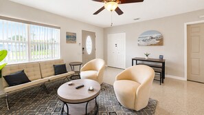 A living room with a sofa, two armchairs, a coffee table, and a ceiling fan. - Tropical Pool Oasis, Pet Friendly & Near Beaches! (Seminole)