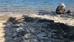 A rocky shoreline with clear water and distant land. - Welcome to The Cedars.
Beautifully maintained waterfront quaint log cabin (Northeastern Manitoulin and the Islands)