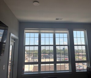 Ein Zimmer mit großem Fenster und Blick auf einen Parkplatz und Gebäude.