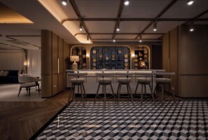 A modern kitchen with a bar area, bar stools, and a patterned floor. - Title Serenity Naiyang: pool access (Thalang District)