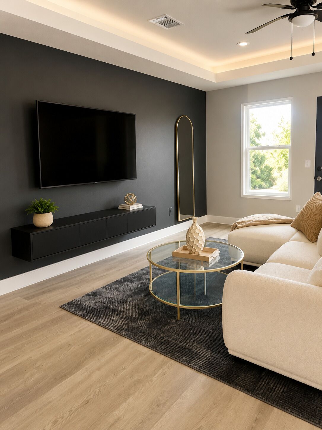 A modern living room with a flat-screen TV, a round coffee table, a sofa, and a large window.