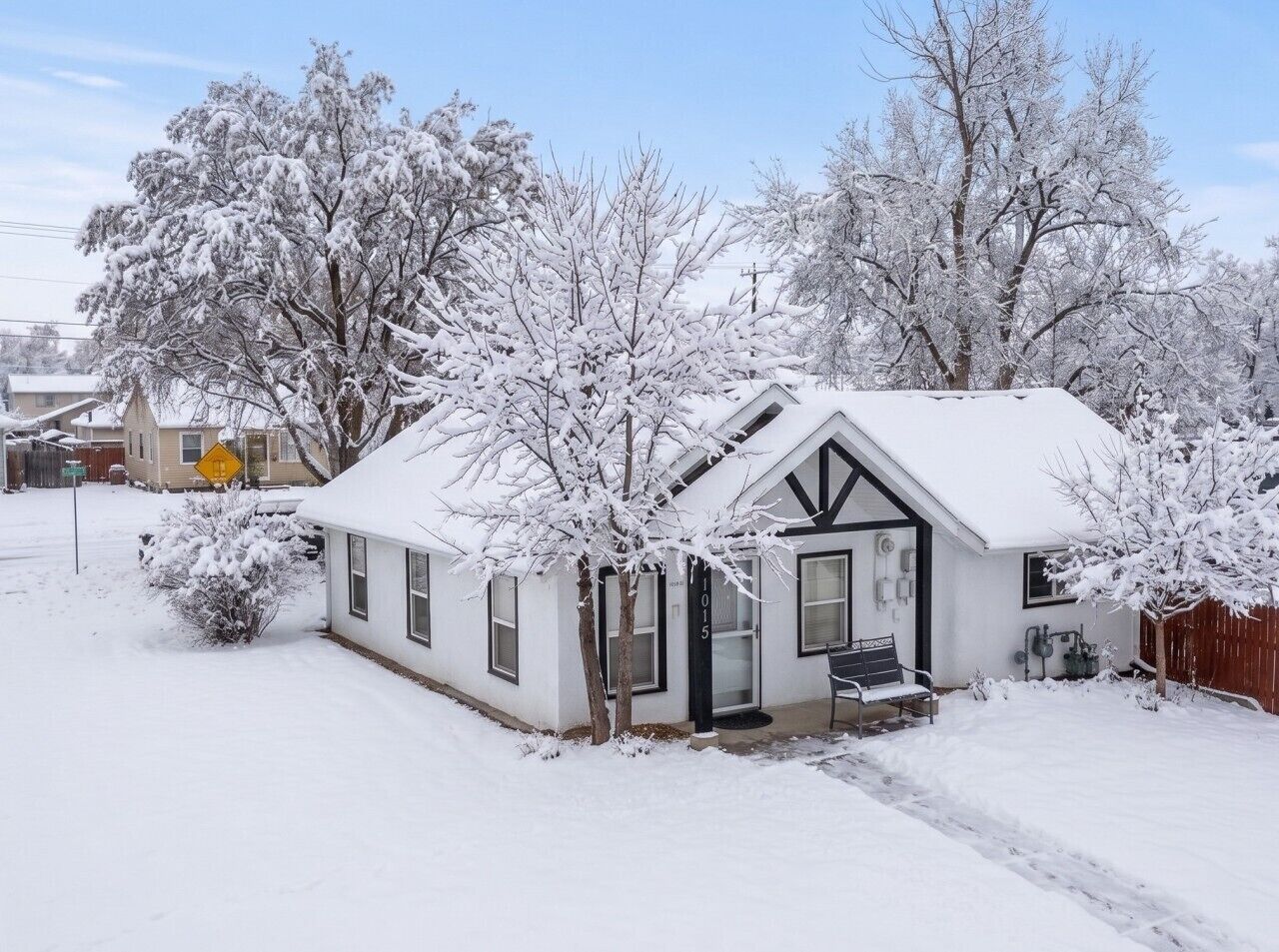 A single-story house with a snow-covered roof and a visible garage door.