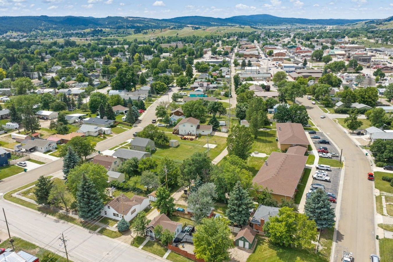 Un quartier résidentiel composé de maisons, de rues et d’une route principale.