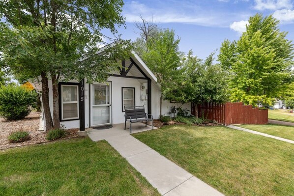 A single-story house with a front porch, a bench, and a mailbox.