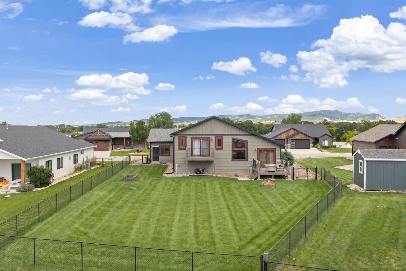 A residential area with houses, a well-maintained lawn, and a clear sky.