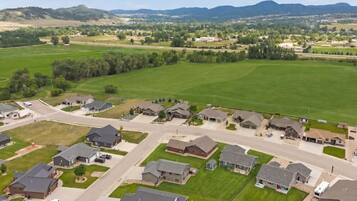 A residential area with houses, roads, and green fields.