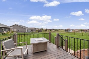 A deck with a table and chairs, overlooking a well-maintained lawn and neighboring houses. - 3BR 2BA, Spearfish Retreat, Deck & Fenced Yard (Spearfish)