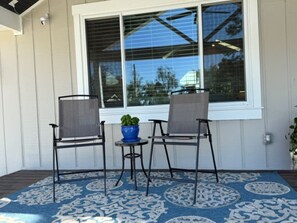 Eine Terrasse mit zwei Stühlen, einem kleinen Tisch und einem Blumentopf.