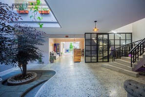 A spacious indoor area with a central atrium, a staircase, and a seating area. - HOTEL BOUTIQUE POMA ROSA (Medellin)