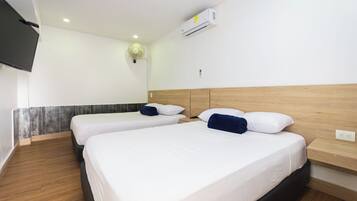 Een hotelkamer met twee bedden, een flatscreen televisie aan de muur en een airconditioning boven de bedden.