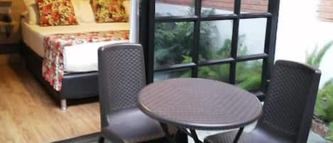 Una habitación con cama, ventana y una mesa con dos sillas.