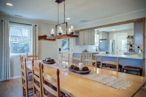 A dining area with a wooden table, chairs, and a chandelier. - Snowflake Lodge - 4BR on App Ski Mountain! (Blowing Rock)