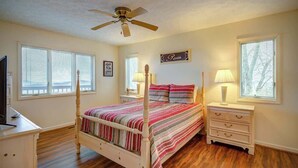 A bedroom with a four-poster bed, a ceiling fan, bedside lamps, a nightstand, a dresser, and a wall-mounted sign. - Blue Mountain Breeze with multi-mountain range vie (Blowing Rock)