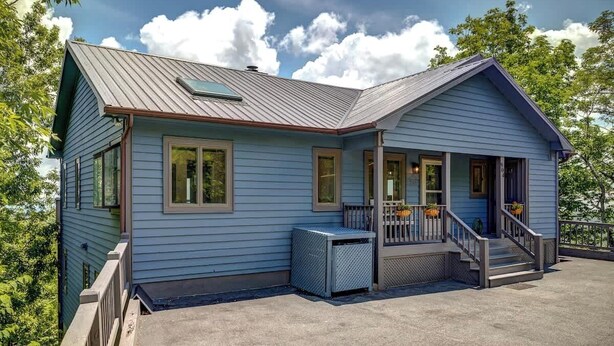 A two-story house with a porch, a covered front porch area, and a small attached garage. - Blue Mountain Breeze with multi-mountain range vie (Blowing Rock)