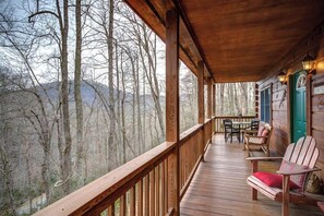 A wooden deck with a view of a forest and mountains. - Arbor Den Log Cabin 3 Bedroom, 3 Bath, Pet friendly (Blowing Rock)