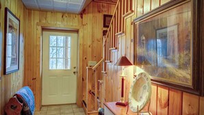 A wooden interior with a door, a staircase, and a framed painting. - Arbor Den Log Cabin 3 Bedroom, 3 Bath, Pet friendly (Blowing Rock)