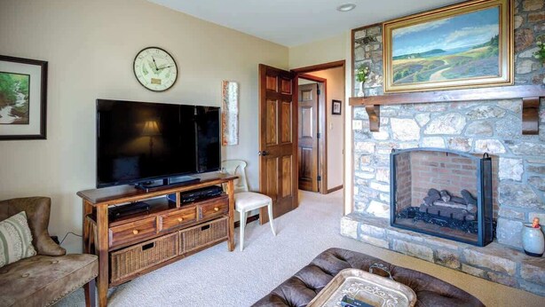 A living room with a fireplace, television, and a stone wall. - Blissful Vista has breathtaking gorge views, seclu (Blowing Rock)