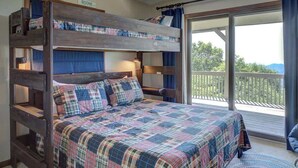 A bunk bed with a plaid bedspread and pillows, a wooden headboard, and a balcony with a view. - Blissful Vista has breathtaking gorge views, seclu (Blowing Rock)