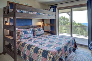 A bunk bed with a plaid bedspread and pillows, a wooden headboard, and a balcony with a view. - Blissful Vista has breathtaking gorge views, seclu (Blowing Rock)