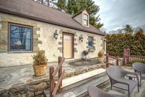 A stone house with a wooden porch, a door, and a window. - The Hill is the best in country living, minutes fr (Blowing Rock)