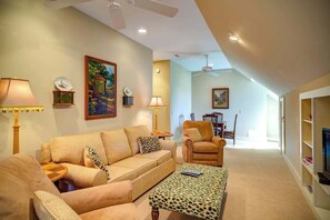 A living room with a sofa, armchair, and ottoman, a dining area with chairs, and a ceiling fan. - The Hill is the best in country living, minutes fr (Blowing Rock)
