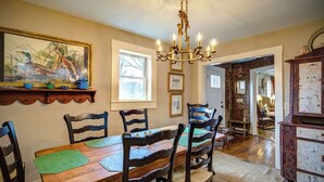 A dining area with a wooden table, chairs, and a chandelier. - The Hill is the best in country living, minutes fr (Blowing Rock)