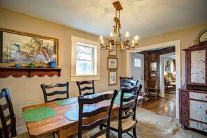 A dining area with a wooden table, chairs, and a chandelier. - The Hill is the best in country living, minutes fr (Blowing Rock)