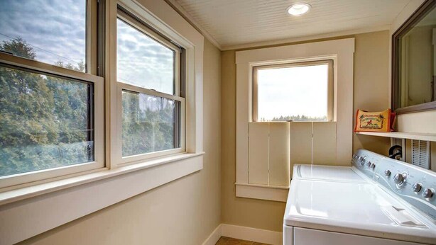 A laundry room with a washer and dryer, large windows, and a view of trees. - The Hill is the best in country living, minutes fr (Blowing Rock)