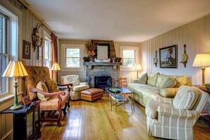 A traditional living room with a fireplace, wooden flooring, and classic furniture. - The Hill is the best in country living, minutes fr (Blowing Rock)