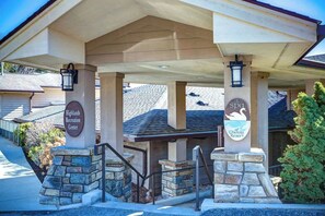 A building entrance with a covered porch, stone pillars, and signage for Highlands Recreation Center and Chetola Resort. - One Level Entry 3 bed 3 bath condo at Chetola (Blowing Rock)