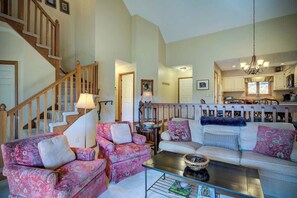 A spacious living room with a staircase, a dining area, and a kitchen. - One Level Entry 3 bed 3 bath condo at Chetola (Blowing Rock)
