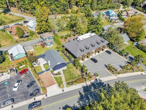 An aerial view of a residential area with houses, a parking lot, and a road. - Little House on Main in Downtown Blowing Rock (Blowing Rock)