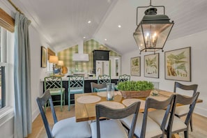 A dining area with a wooden table, chairs, and a hanging lantern. - Little House on Main in Downtown Blowing Rock (Blowing Rock)