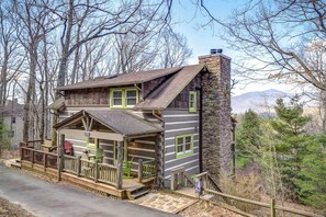 A cabin with a stone chimney, a porch with chairs, and a view of trees and mountains. - Cabin on Mistleoe 3 Bed 3 Bath Log cabin near Blowing Rock (Blowing Rock)